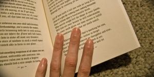 Image of someone's hand holding a book open